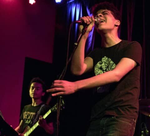 A singer belts out a song onstage.